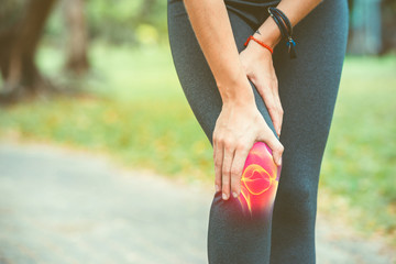 Woman holding her knee with red pain