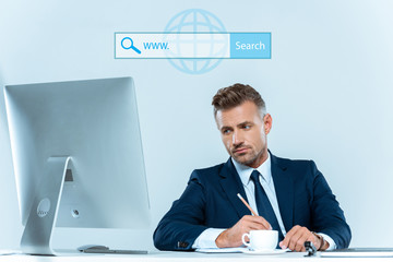 Wall Mural - handsome businessman looking at computer at table isolated on blue with search bar