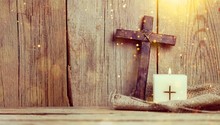 Burning Candle And Cross On Wooden Background