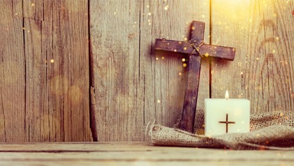 Canvas Print - Burning candle and cross on wooden background