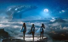 Surreal Dream With Three Surfer Girls Standing On The Top Above Clouds And Landscape, Big Whale Hovering In The Space Under Full Moon On Background