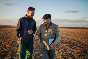 Farmers in the field use advanced technology.