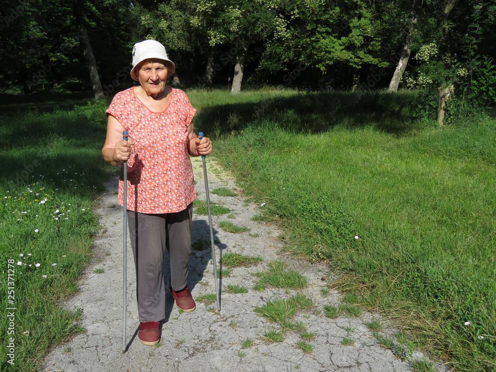 Nordic walking, therapy for health. Old woman walking with sticks in ...