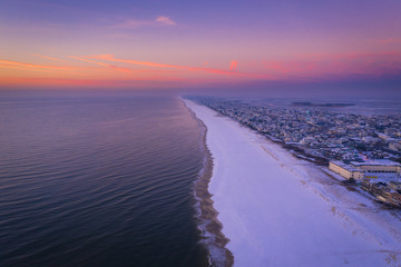 Wall Mural - Long Beach Island at sunrise in the winter with snow on the beach