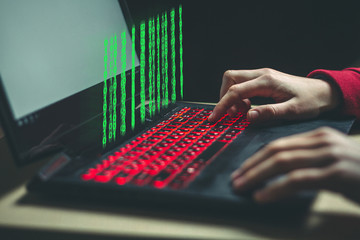 Hacker works and breaks into personal data and infects system with a virus using laptop. Hacker attack, cyber security. Hacking and identity theft, fraud, scam concept