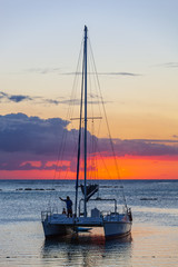 Wall Mural - Sea voyage on a sail catamaran at sunset, Mauritius island