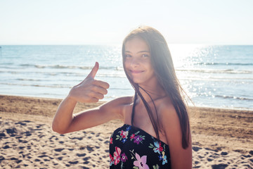 Wall Mural - portrait of a girl by the sea, thumb up, cool sign, ok, everything is fine
