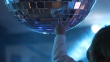 The Child Stretches And Touches The Disco Ball. The Rotating Disco Mirror Ball. Rotating Sparkling Disco Ball.