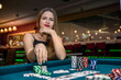 © RomanR - Beautiful woman in casino taking chips from pile