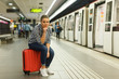 © JackF - Woman sitting on suitcase at metro station