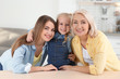 © New Africa - Portrait of young woman, her mature mother and daughter at table indoors