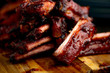 Smoked ribs ready to be eaten on wooden plate.​