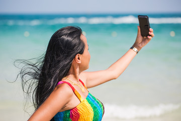 Wall Mural - Beautiful asian woman is taking a selfie at the beach