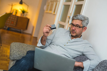 man using laptop for online shopping from his home