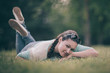 © yurolaitsalbert - cute young woman lying on green grass.