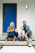 © Jessica Peterson/Tetra Images - Portrait of smiling family sitting on steps