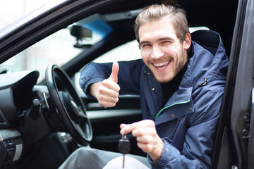 happy man showing thumb up and the keys to his car