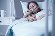 © Photographee.eu - Sad kid with cystic fibrosis lying in a hospital bed with oxygen mask and plush toy