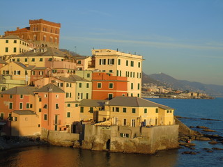 Genova, Italy - 02/14/2019: An amazing caption of the sunset over the sea and the city of Genoa in winter days and great views to the old buildings near the beach coloured by the sun