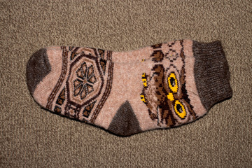 Wall Mural - A pair of warm winter wool socks with patterns on a knitted background.