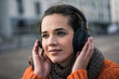 © Westend61 - Portrait of smiling woman wearing listening music with cordless headphones in autumn