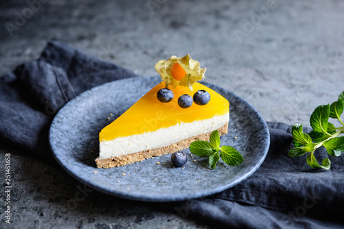 Fotografering  No bake mango cheesecake decorated with blueberries and physalis