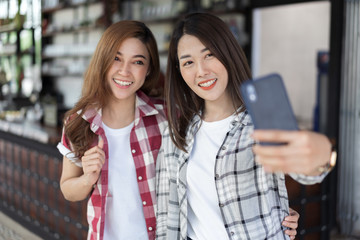 Sticker - two cheerful woman taking selfie on smartphone