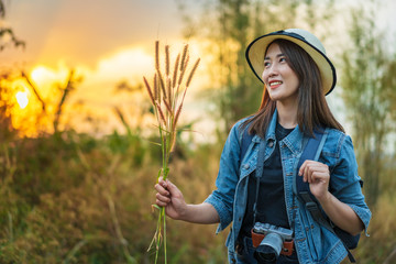 Sticker - female tourist with backpack and camera in countryside with sunset