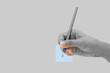 © feelartfeelant - Female hand with blue color pencil isolated on grey background.