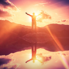 Copy space of man rise hand up on top of mountain and sunset sky abstract background.