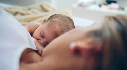 Newborn lying on the bed with her mother