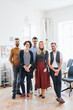 © Halfpoint - A portrait of group of young businesspeople standing in a modern office.
