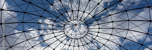 Cuadros en Lienzo Bottom view of an iron structure with blue sky and clouds in the background