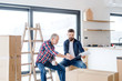 © Halfpoint - A senior man helping his son with furnishing new house, a new home concept.