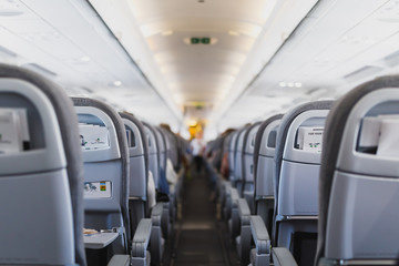 airline passenger seats and aisle in airplane cabin