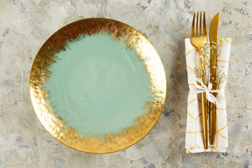 Table setting arrangement in minimal style with easter spring holiday attributes, fork, knife and napkin. Background, copy space, close up, flat lay, top view.