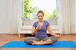 © Syda Productions - fitness, technology and healthy lifestyle concept - woman with smartphone doing yoga at home