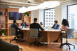 © Monkey Business - Group Of Business Professionals Meeting Around Table In Modern Office
