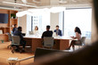 © Monkey Business - Group Of Business Professionals Meeting Around Table In Modern Office