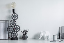 Modern And Stylish Black And White Home Decor Mock Up. Creative Desk With Blank Picture Frame Or Poster, Desk Objects, Office Supplies, Elephant Figure And Design Table Lamp On A White Background.