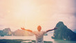 Leinwandbild Motiv Feel good freedom and travel adventure concept. Copy space of happy man raise hands on  top of mountain with sun light abstract background.