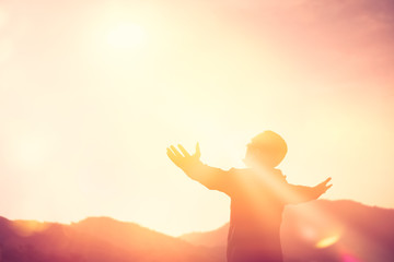copy space of man rise hand up on top of mountain and sunset sky abstract background.