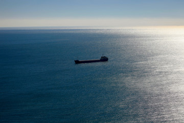 Blue sea in the sunlight in the morning and a large cargo ship