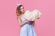 © oes - Cheerful young lady with long brown hair  being excited to get bouquet of spring flowers on women's day isolated over pink background.
