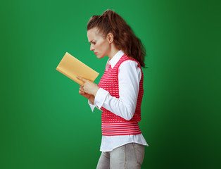 Wall Mural - healthy learner woman reading yellow book isolated on green