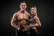© Maksim Toome - Sporty young couple posing on black background