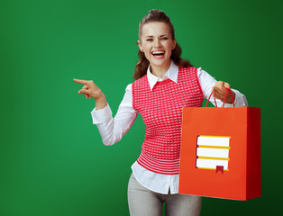 Wall Mural - student woman with red shopping bag with books pointing at somet