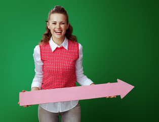 Wall Mural - smiling learner woman holding big pink arrow pointing right