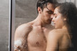 man and woman hugging and taking shower with loofah in cabin