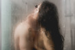 selective focus of naked man and woman hugging and kissing in shower cabin